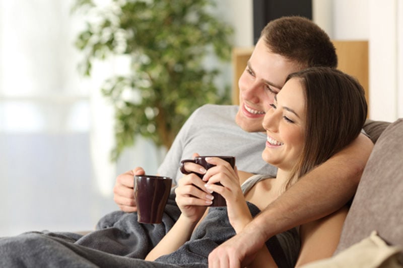 Happy Couple Sitting In Living Room